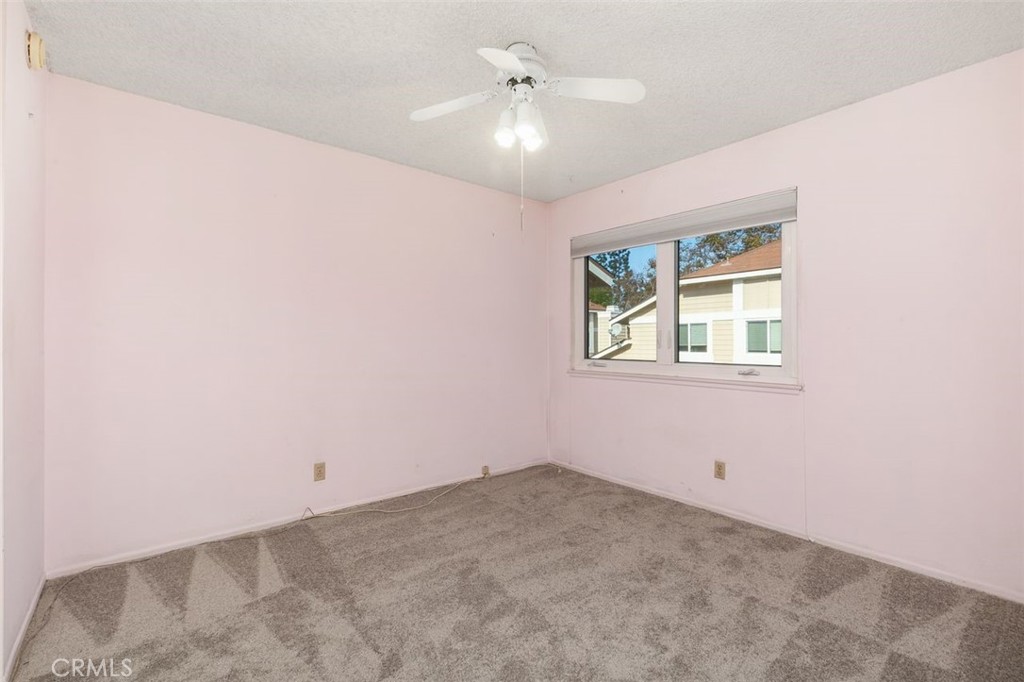 7718 Rambling Brook Way Stanton, CA 90680 - Photo 15 of 23 an empty room with windows and ceiling fan