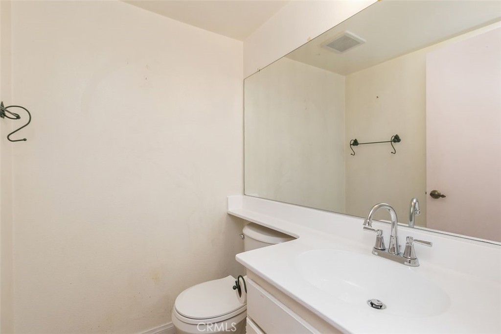 7718 Rambling Brook Way Stanton, CA 90680 - Photo 16 of 23 a bathroom with a sink a toilet and mirror