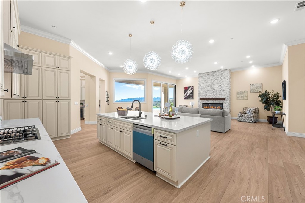 25700 El Chaval Place Temecula, CA 92590 - Photo 20 of 66 a kitchen with stainless steel appliances kitchen island granite countertop a stove a sink a refrigerator and white cabinets with wooden floor