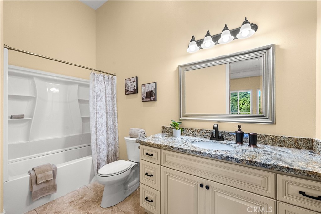 25700 El Chaval Place Temecula, CA 92590 - Photo 31 of 66 a bathroom with a granite countertop sink mirror vanity and toilet