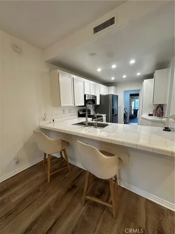 a kitchen with a sink cabinets and wooden floor