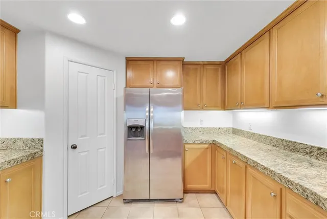 a kitchen with granite countertop stainless steel appliances a refrigerator and cabinets