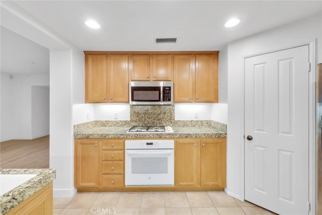 211 Lockford Irvine, CA 92602 - Photo 22 of 47 a kitchen with stainless steel appliances granite countertop a stove and a sink