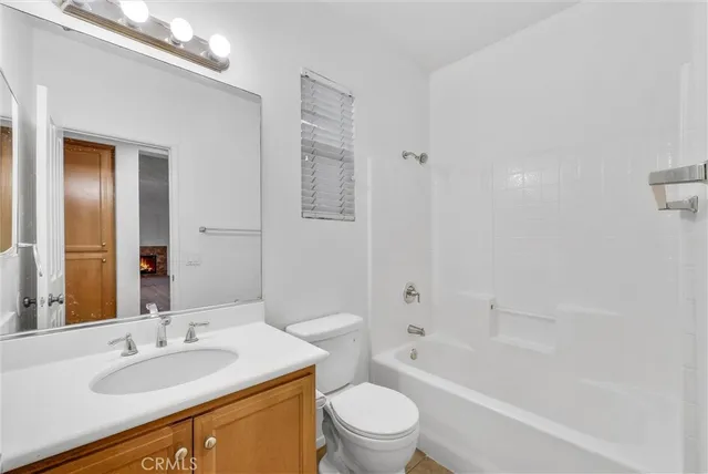 a bathroom with a granite countertop sink toilet mirror and bathtub