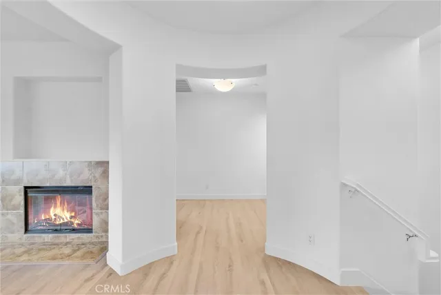 a hallway with a fireplace and a wooden floor