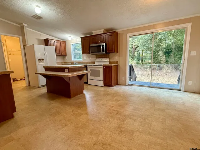a large kitchen with a large window and stainless steel appliances