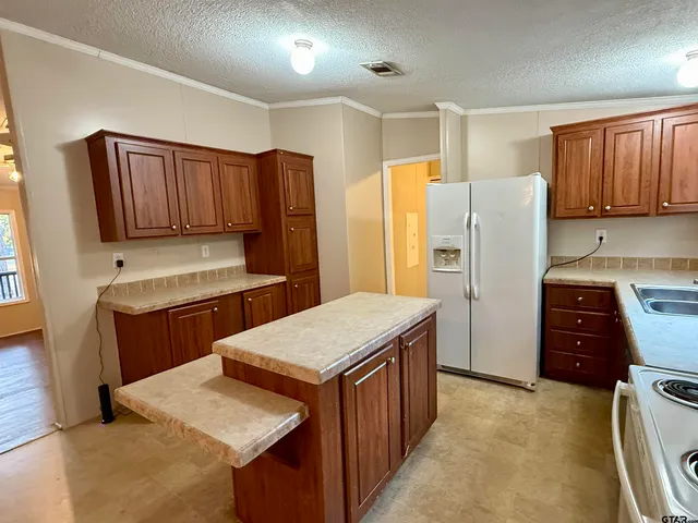 a kitchen with stainless steel appliances granite countertop a refrigerator and a stove