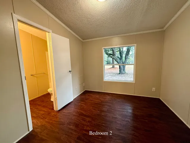 an empty room with wooden floor and entrance