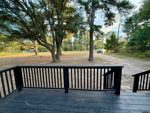 a balcony with wooden floor and fence