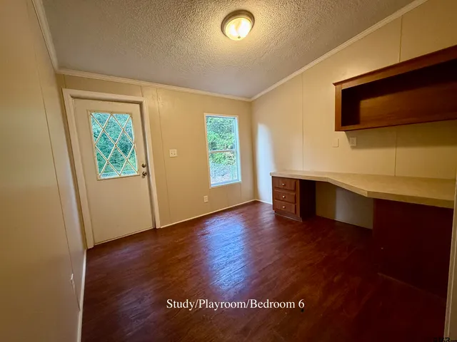 an empty room with wooden floor and door