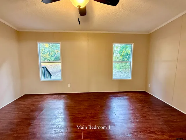 a view of an empty room with wooden floor