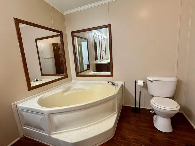 a bathroom with a tub sink and mirror