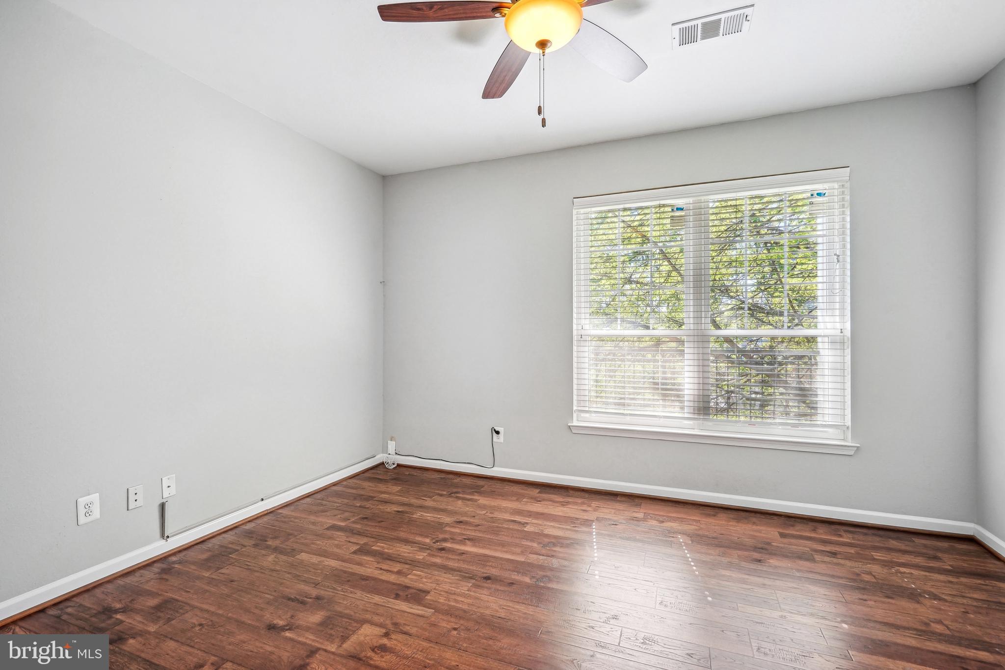 1601 Spring Gate Dr., Unit 1210 McLean, VA 22102 - Photo 13 of 18 an empty room with wooden floor and windows