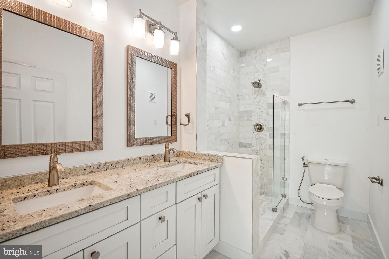 1601 Spring Gate Dr., Unit 1210 McLean, VA 22102 - Photo 10 of 18 a bathroom with a granite countertop sink a toilet and a large mirror