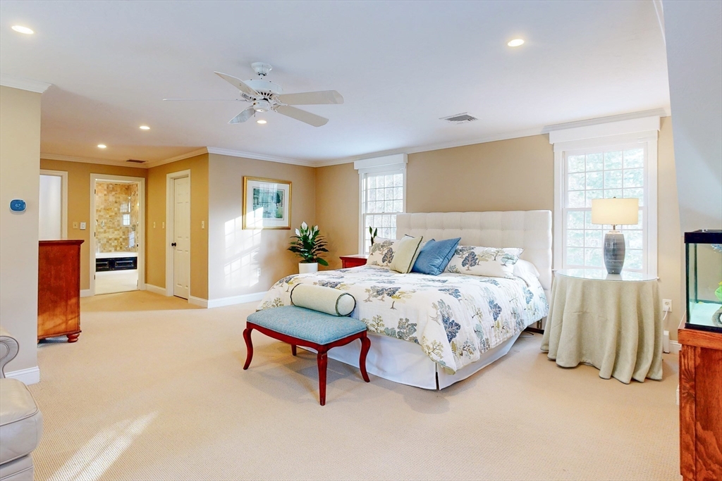 1 Chestnut Lane Medfield, MA 02052 - Photo 18 of 42 a spacious bedroom with a bed and a chandelier