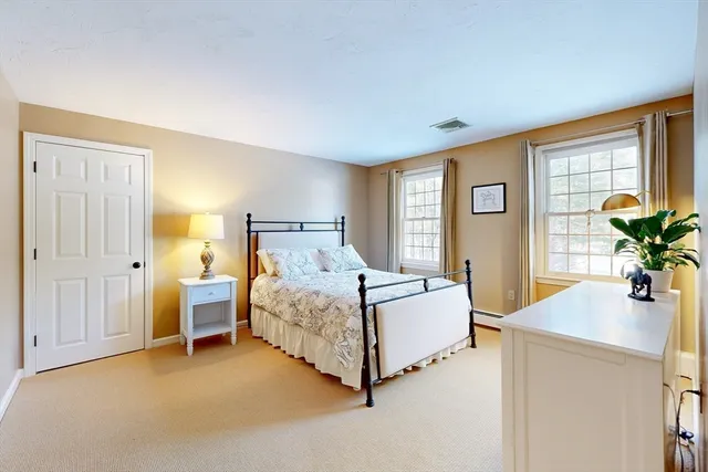 a bed sitting in a bedroom next to a window