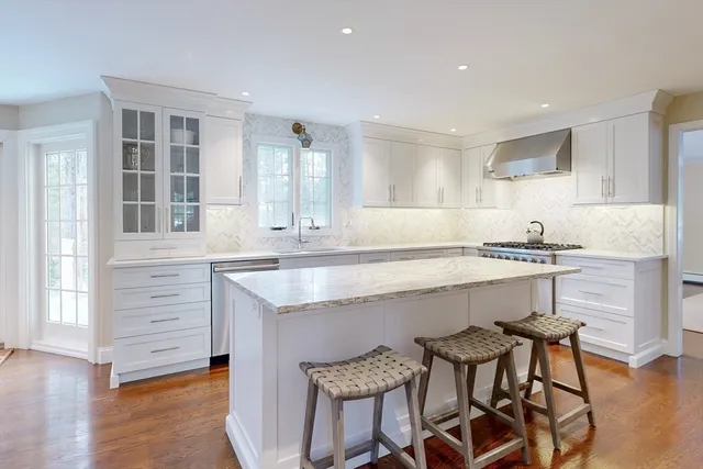 a large kitchen with stainless steel appliances granite countertop a sink stove and refrigerator