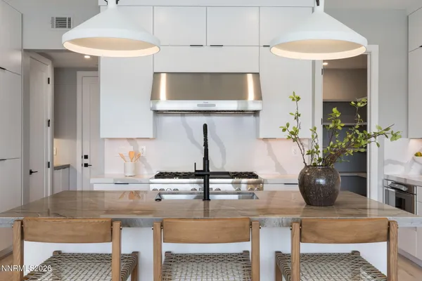 a kitchen with stainless steel appliances granite countertop a sink a stove and a wooden floors