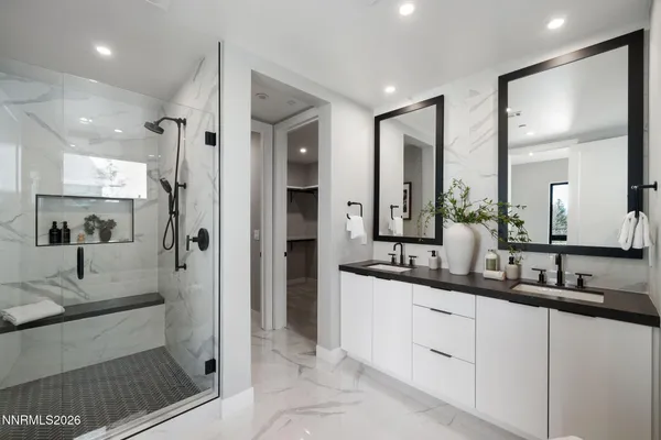 a bathroom with a double vanity sink a mirror and a window