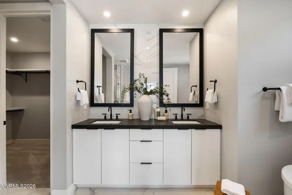 a bathroom with a double vanity sink mirror and shower