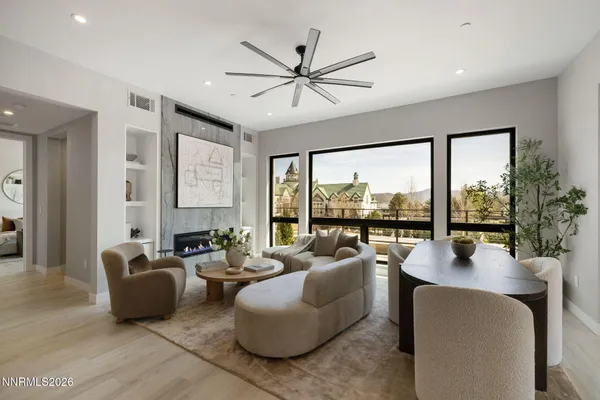 a living room with furniture floor to ceiling windows and a table