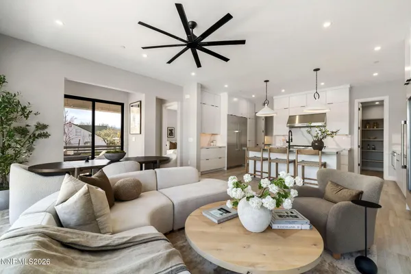 a living room with furniture potted plant and a large window