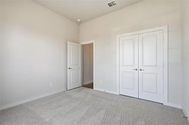 a view of an empty room with chandelier fan and fire place