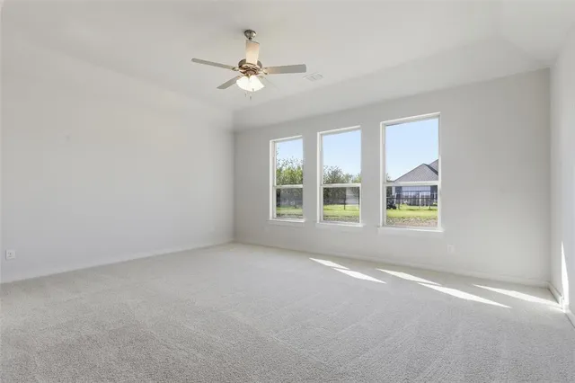 an empty room with a window and a ceiling fan
