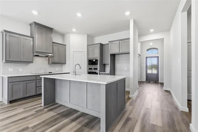 a kitchen with stainless steel appliances granite countertop a sink stove and refrigerator