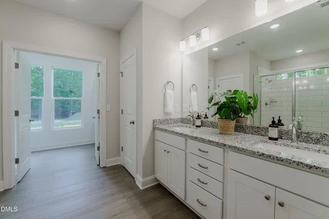 a bathroom with a granite countertop sink mirror and shower