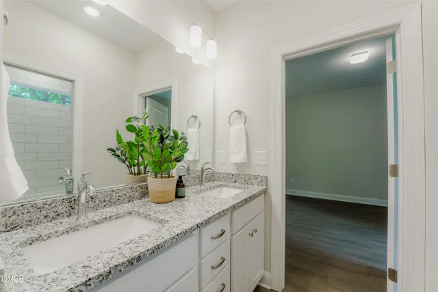 a bathroom with a granite countertop sink and a mirror