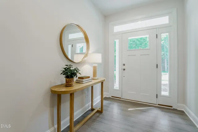 a view of a room with wooden floor and mirror