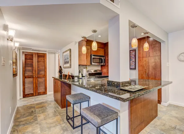 a kitchen with stainless steel appliances granite countertop a stove a sink and a refrigerator
