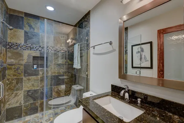 a bathroom with a double vanity sink toilet and shower