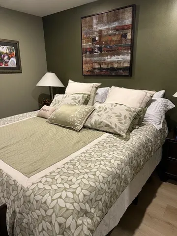 a bedroom with bed and painting on the wall