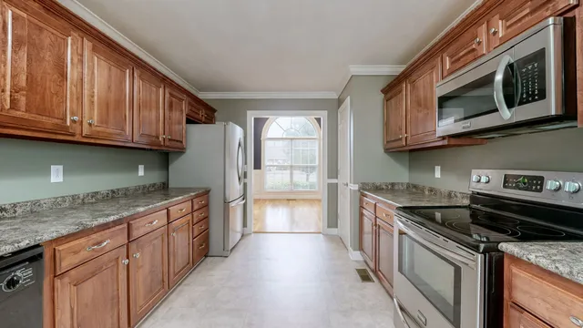a kitchen with stainless steel appliances granite countertop wooden cabinets and a stove top oven