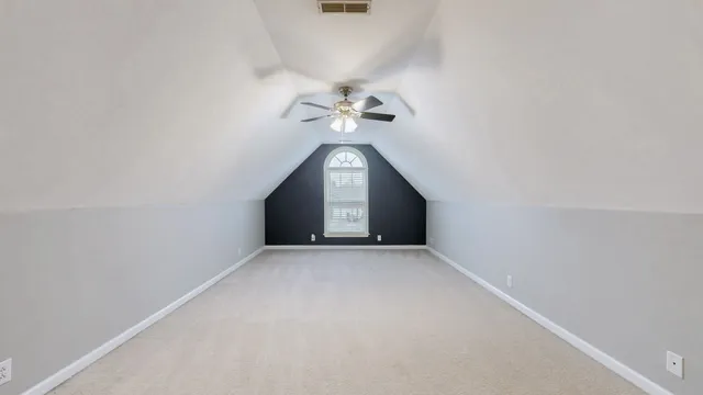 a view of a big room with ceiling fan and window