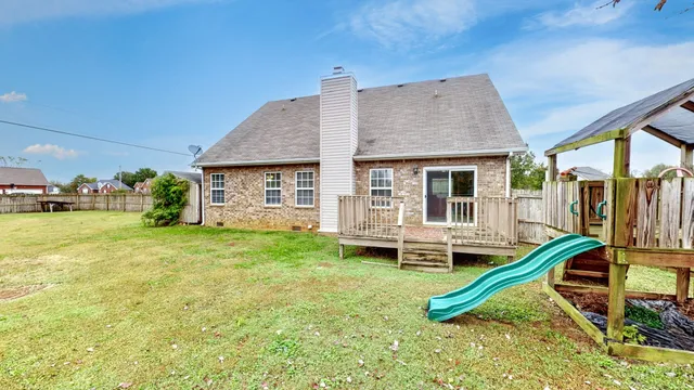 a view of a house with a backyard and deck