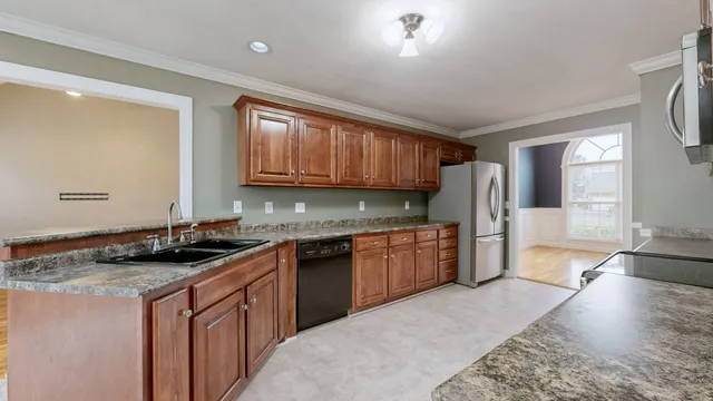 a kitchen with stainless steel appliances granite countertop a stove a sink and a refrigerator