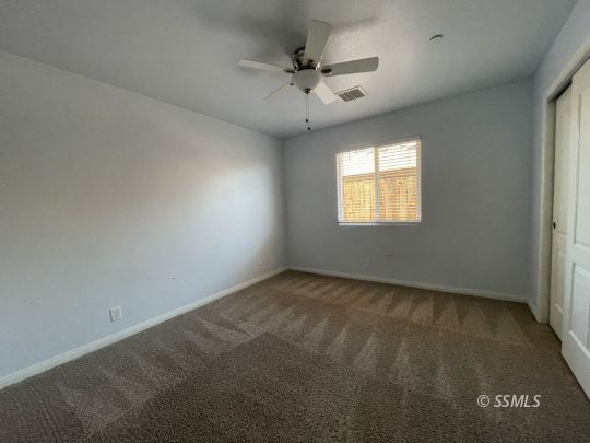 1224 South McCall Street Ridgecrest, CA 93555 - Photo 8 of 9 an empty room with a window and a ceiling fan