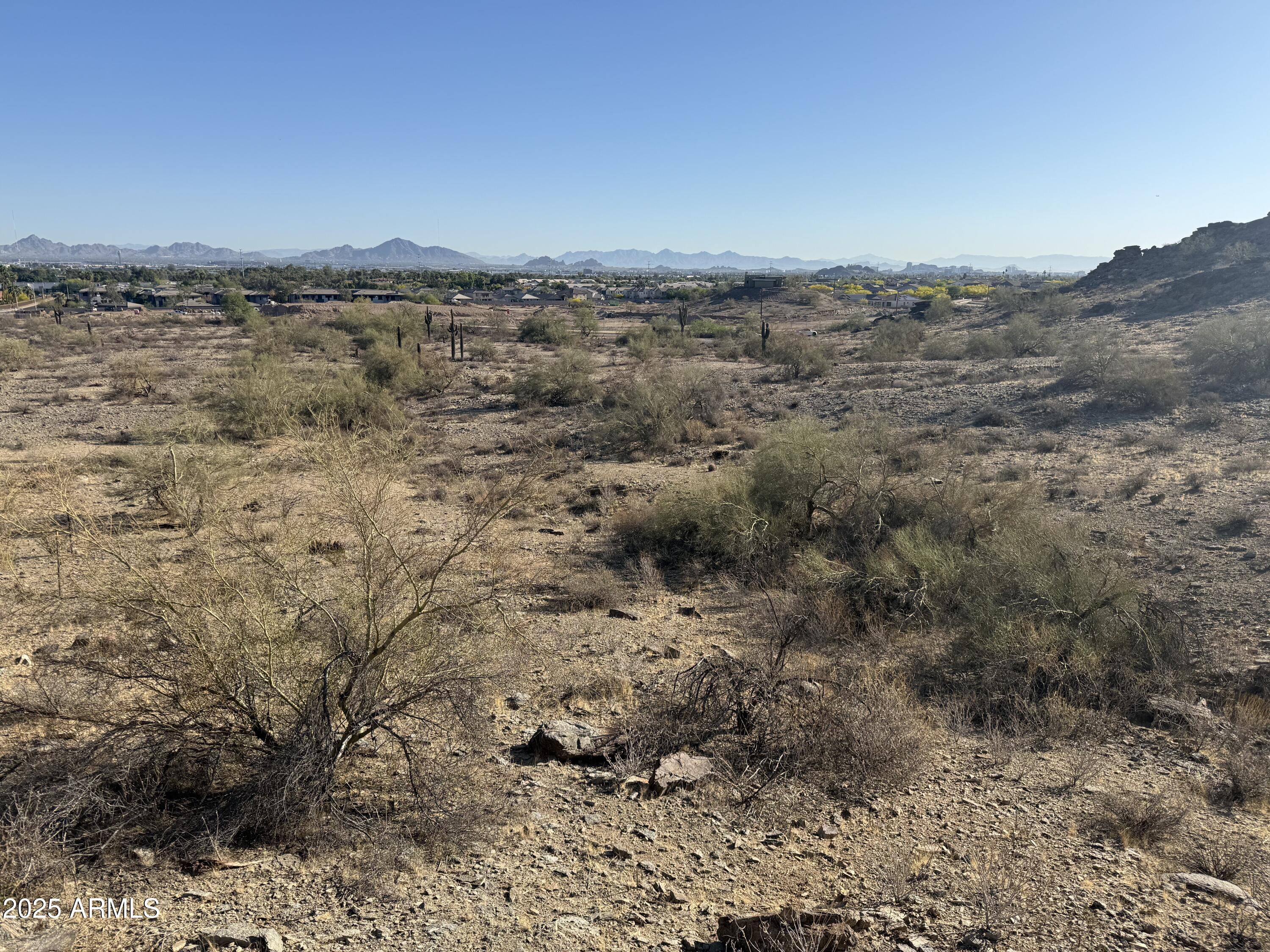 3670 East Highline Canal Road Phoenix, AZ 85042 - Photo 7 of 17 a view of a dry yard with mountains in the background
