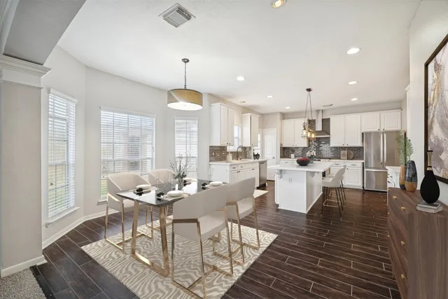 a view of a dining room and livingroom with furniture wooden floor a rug a fireplace
