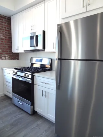 a kitchen with stainless steel appliances a refrigerator sink and microwave