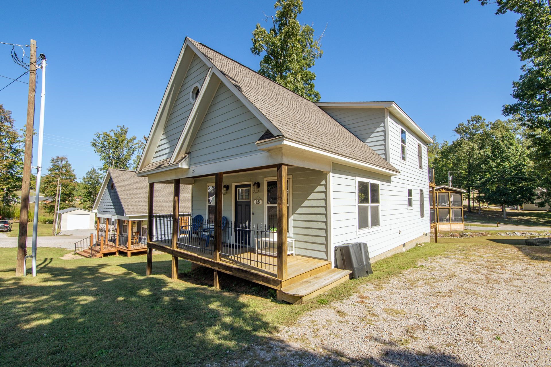 25 Bogey Loop Counce, TN 38326 - Photo 37 of 37 Rear view of house with roof with shingles, a lawn, an outdoor structure, and covered porch