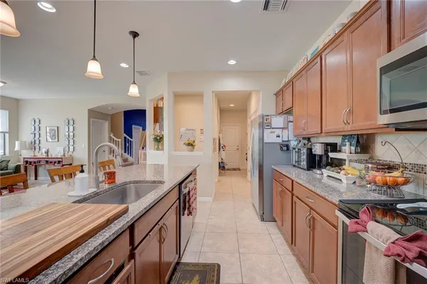 a kitchen with stainless steel appliances granite countertop a sink a stove and a wooden floors