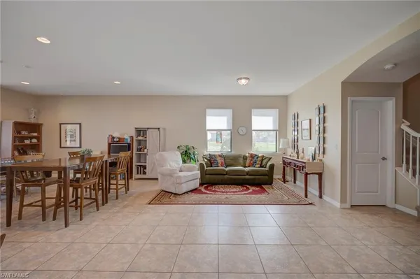 a living room with furniture a dining table and a large window