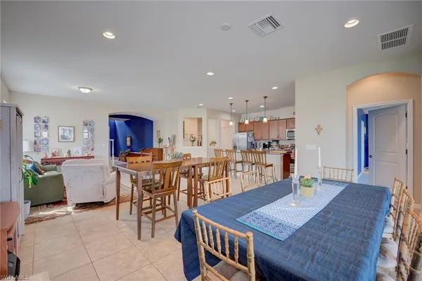 a open dining room with kitchen island a table and chairs