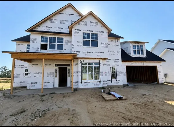 a view of a house with a yard and large parking space