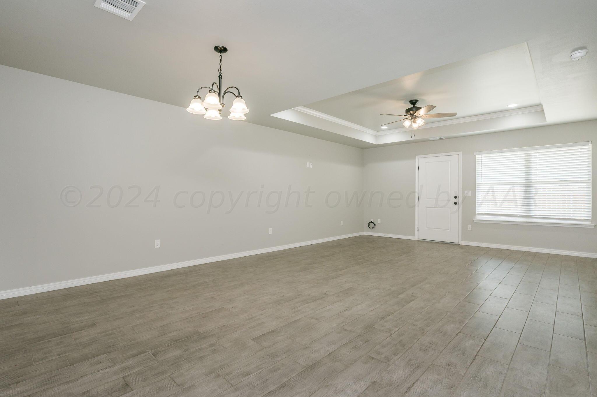 13987 Periwinkle Drive, Unit 1 Amarillo, TX 79119 - Photo 4 of 20 wooden floor in an empty room with a window