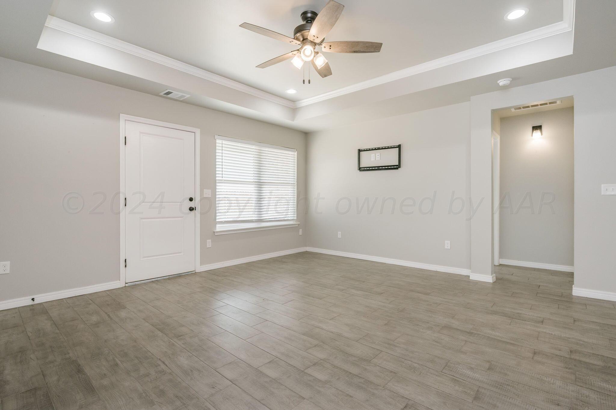 13987 Periwinkle Drive, Unit 1 Amarillo, TX 79119 - Photo 5 of 20 wooden floor in an empty room with a window